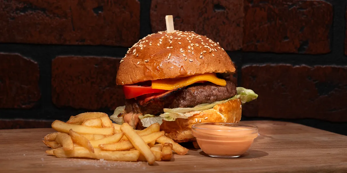 Hovězí burger v sezamové housce s hranolkami a dipem